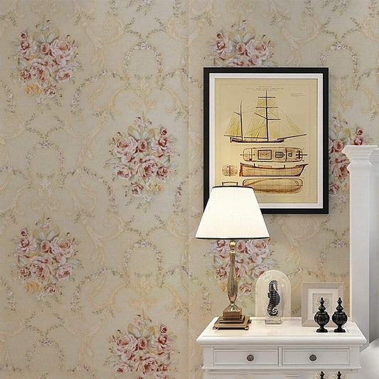 Vintage-style floral wallpaper in beige with pink and yellow rose clusters and ornate vine patterns.